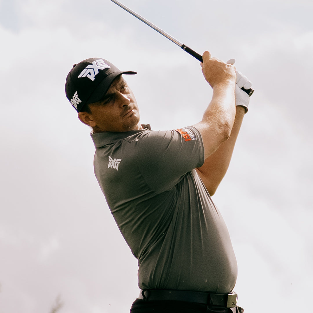 PGA Tour Pro Christiaan Bezuidenhout wearing a PXG Golf Hat against a gray sky.