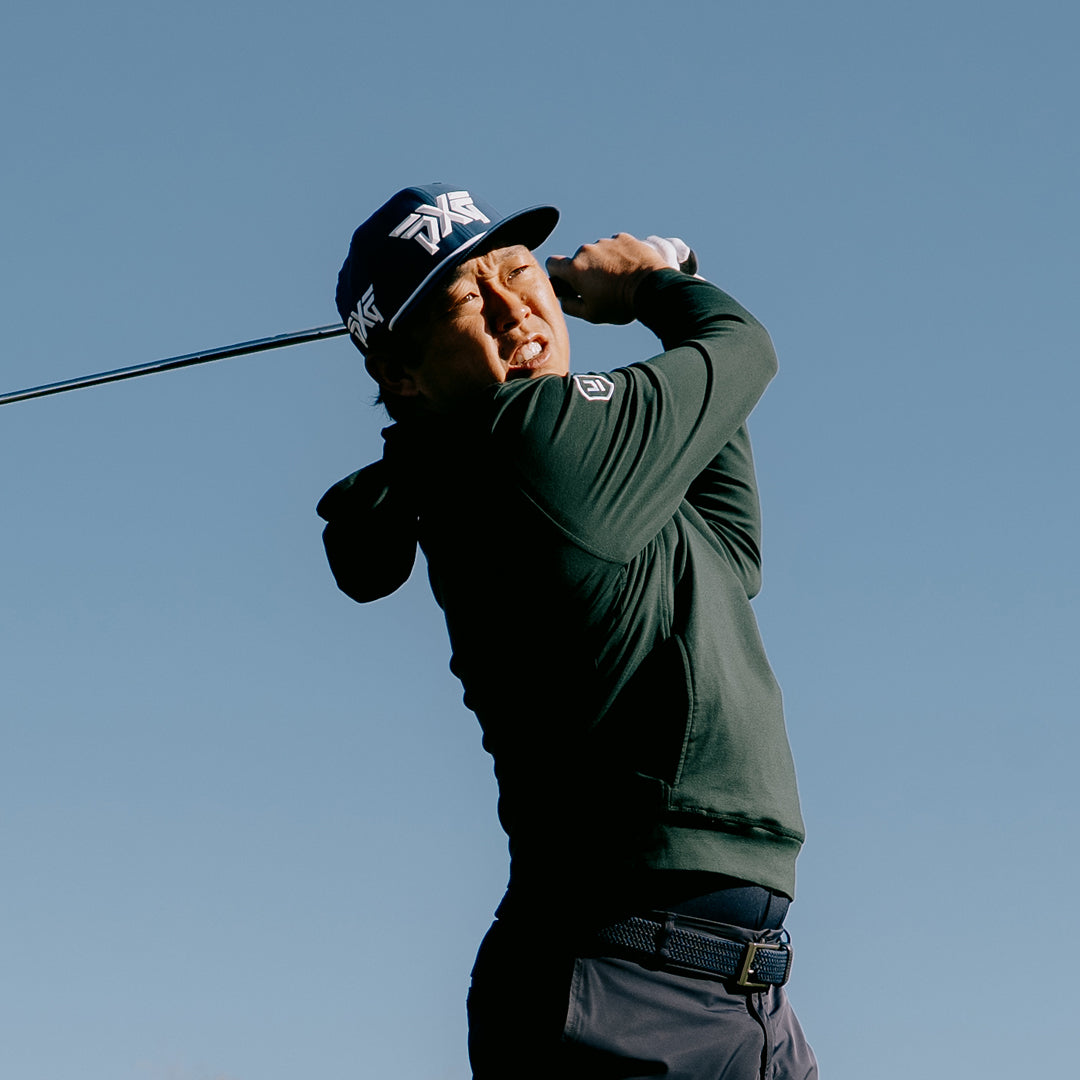 PGA Tour Pro David Lipsky wearing a PXG Golf Hat against a blue sky.