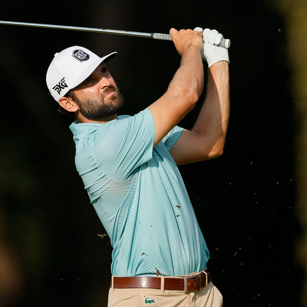 Pro Paul Barjon wearing a PXG Hat and swinging a golf club on a golf course.